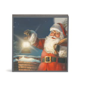 A square wall art of Santa holding his bag of gifts and a lantern next to a chimney.