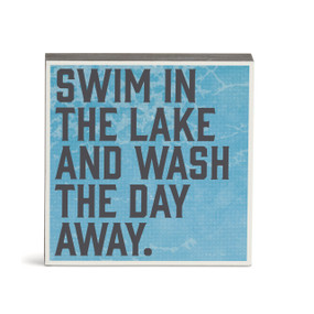 A blue wall art with the saying "Swim in the lake and wash the day away".