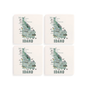 A set of four white square coasters with a map illustration of Idaho with famous landmarks and cities.