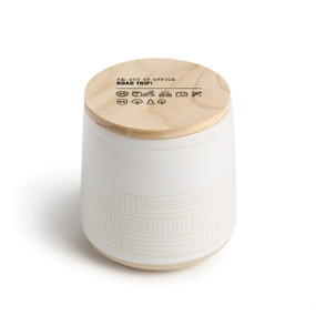 A white ceramic jar candle. The lid is wood and has the saying "Re: Out of Office Road Trip!" with a set of emoji images related to road trips.