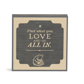 A dark gray and brown wall art with Pooh eating honey and the saying "Find what you Love and Go All In".