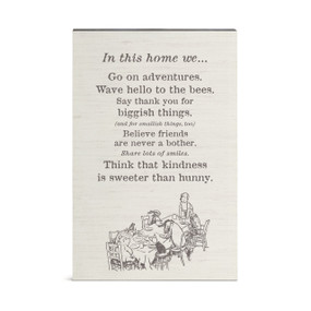 A wall art of Pooh and friends around a table and a saying about what we do "In this home..."