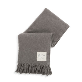 A gray fringed blanket with a fabric patch in the lower right corner that says "Darling, Snuggle Up and Stay Awhile. XOXO".