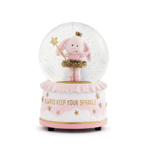 Front view of a musical snow globe. The base of the globe is pink and white. "Always Keep Your Sparkle" is printed in gold on the base. Inside the globe is a figurine of a pink bunny wearing a crown and a gold tutu and holding a scepter with a star on top.