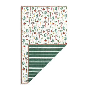 Top down view of a kitchen towel with a print of various root vegetables on a white background on the front. The bottom right corner is folded up to show the back of the towel, which has a print of dark green and white stripes.