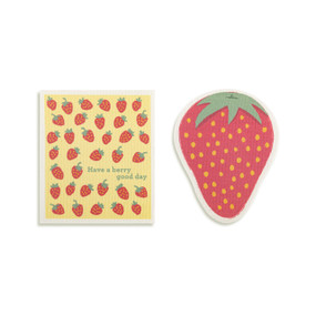 Top down view of a set of biodegradable dish towels set side by side. The towel on the right is shaped like a strawberry. The towel on the left is rectangular and has a print of strawberries on a yellow background.