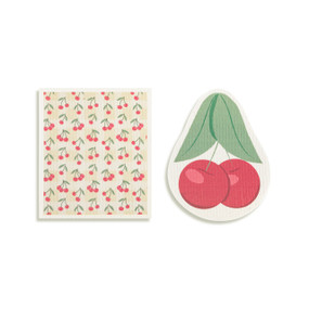 Top down view of a set of biodegradable dish towels set side by side. The towel on the right is shaped like two cherries on stems with leaves. The towel on the left is rectangular and has a print of cherries on a pale yellow background.