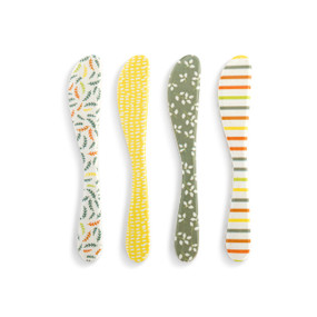 Top down view of a set of 4 melamine spreaders. Each spreader is a different color and pattern, unified with warm colors like green, orange and yellow