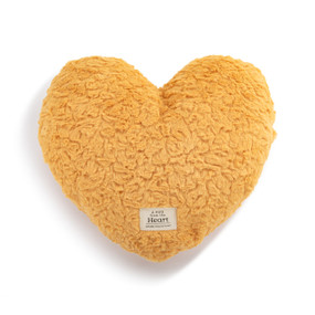 Top down view of a mustard yellow heart shaped weighted pillow. A patch at the bottom of the heart, reads "A hug from the heart."