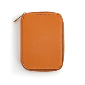 Top down view of the front of a saddle brown passport wallet. The wallet is zipped closed, with the zipper pull on the wallet's upper left side.