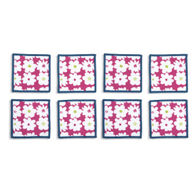 Top down view of four fabric napkins with white flowers printed on a magenta background and navy blue edging, The napkins are arranged in a 2x2 grid and tilted to the left.