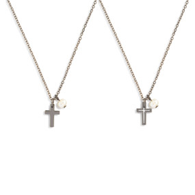 Detail view of two silver necklaces with cross and single pearl pendants.