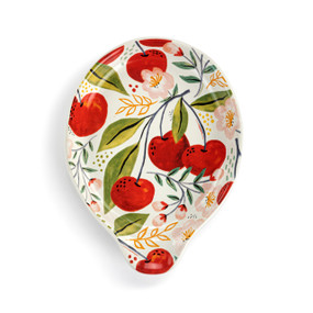 Front view of a ceramic spoon rest with a cherry design on the surface. The spoon rest is turned so the opening is to the bottom.