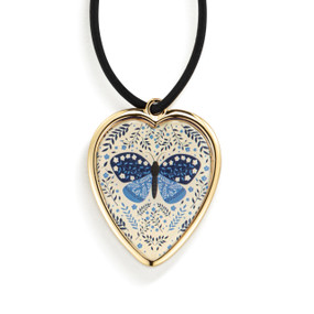 Top down view of the front of a heart shaped gift tag for a wine bottle, strung with a black cord. The heart has an image of a blue butterfly and blue leaves on a cream background.