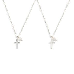 Detail view of two silver necklaces with cross and single pearl pendants.
