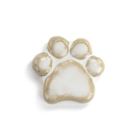 Top down view of a small white paw print shaped ceramic token.