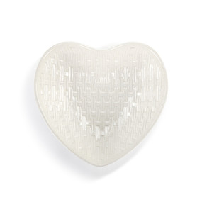 Top down view of a white heart shaped melamine basket, showing the interior. The surface of the basket appears woven.