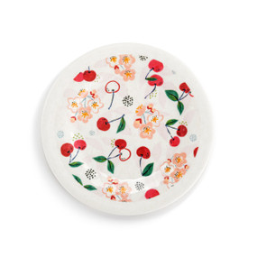 Top down view of a small melamine appetizer plate, decorated with a print of cherries and green leaves.