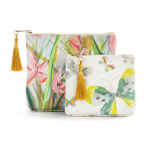 Top down view of two zippered fabric bags. The small bag is in front and slightly to the right of the large bag. The small bag has a pattern of different colored butterflies on a white background. The large bag has an pink and green floral print. The zipper pulls on top of the bags are to the left and have gold tassels attached.
