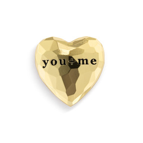 Top down view of a heart shaped gold magnet. The surface of the heart appears faceted and has the words "You &amp; Me" across the top.