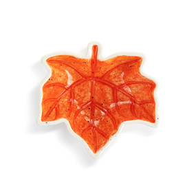 Top down view of a mini ceramic bowl shaped like a maple leaf, showing the red leaf on the interior of the bowl.