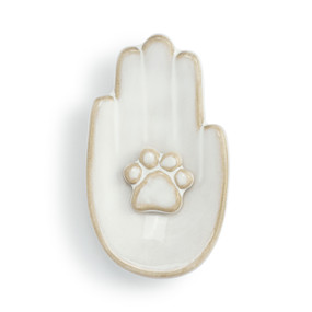 Top down view of a white ceramic trinket dish. The dish is a palm up right hand with an animal pawprint at the center of the palm.