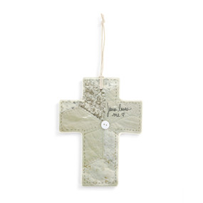 Front view of a ceramic cross, with a cord for hanging threaded through a small hole in the top.  The cross has a patchwork quilt-like pattern in grey and neutral colors, with a small white button at the center. The words "Jesus Loves Me" are written in grey script on the right side of the crossbar.