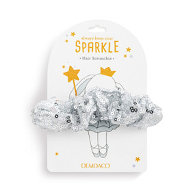 Top down view of a silver sequined hair scrunchie on a white packaging card.