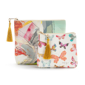 Top down view of two zippered fabric bags. The small bag is in front and slightly to the right of the large bag. The small bag has a pattern of multicolored butterflies on a white background. The large bag has an abstract floral print. The zipper pulls on top of the bags are to the left and have gold tassels attached.