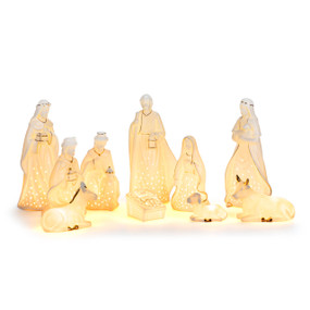 A set of ten white ceramic figures representing the nativity that light up, displayed lit.
