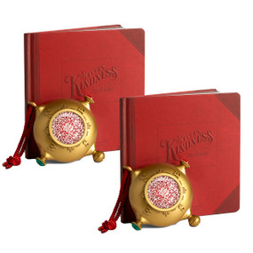 Composite image of  gold ornament that looks a bit like a compass on a red hanger. There is a QR code in the center to scan for videos, displayed next to a red bound journal that says "Santa's Kindness Journal".