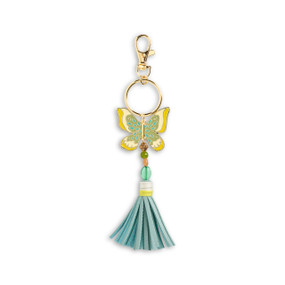 Front view of an green and yellow butterfly bag charm with a turquoise tassel. The charm is attached to a gold ring which hangs from a lobster clasp.