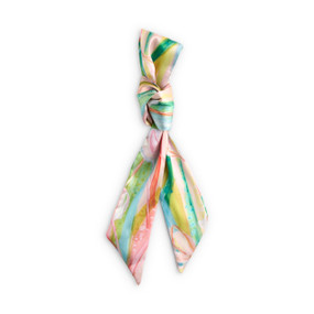 Top down view of a skinny tie style scarf for bags. The scarf is displayed doubled over and tied with a knot at the center. The scarf has a multicolored floral print