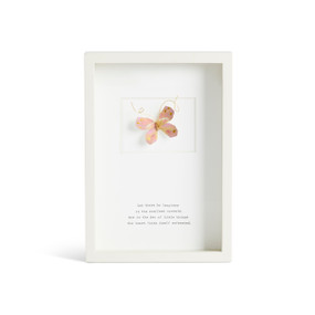 Front facing view of a white rectangular shadow box. At the top is a sculpted pink butterfly with gold markings. "Let there be laughter in the smallest moments. For in the dew of little things the heart finds itself refreshed." is printed in typeface centered at the bottom.