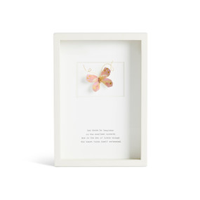 Front facing view of a white rectangular shadow box. At the top is a sculpted pink butterfly with gold markings. "Let there be laughter in the smallest moments. For in the dew of little things the heart finds itself refreshed." is printed in typeface centered at the bottom.