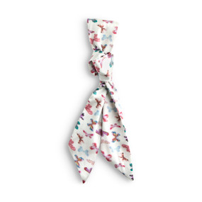 Top down view of a skinny tie style scarf for bags. The scarf is displayed doubled over and tied with a knot at the center. The scarf is white with a pink, purple, and red butterfly print.