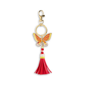 Front view of an orange and yellow butterfly bag charm with a red tassel. The charm is attached to a gold ring which hangs from a lobster clasp.