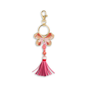Top down view of a pink and red butterfly bag charm with a bright pink tassel. The charm is attached to a gold ring which hangs from a lobster clasp.