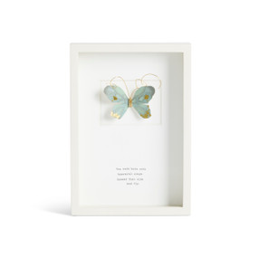 Front facing view of a white rectangular shadow box. At the top is a sculpted blue green butterfly with gold markings. "You were born with beautiful wings. Spread them wide and fly." is printed in typeface centered at the bottom.