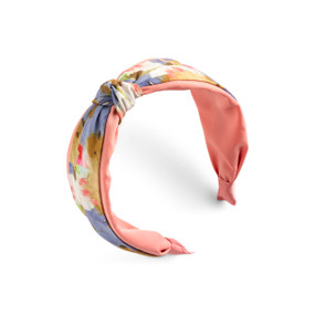 Top down right angled view of a peach and blue butterfly wing printed fabric headband with a knot slightly off center at the top.