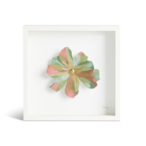 Front view of a white square shadow box. There is a large sculpted green, blue, orange and pink flower at the center,