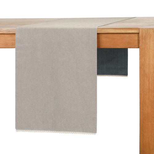 A gray table runner placed on a light wooden table.