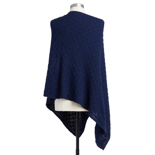 The backside of a soft, navy, knit poncho with five wooden buttons. Placed on a white and black metal mannequin.