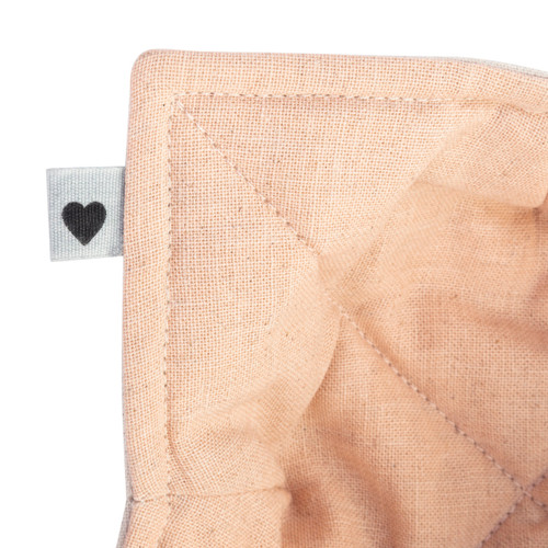 A close up view of the upper left corner with a small gray tag attached with a small black heart.