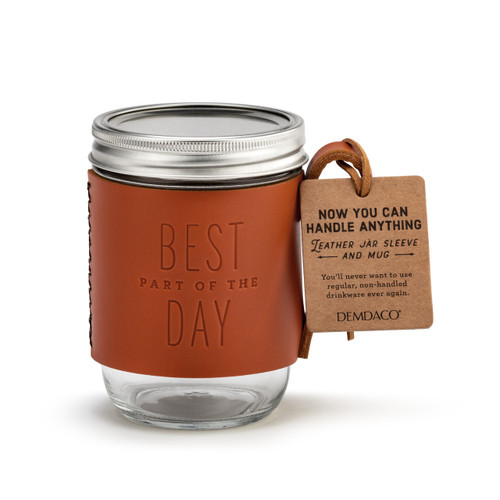 A mason jar with a handled leather sleeve that says "Best Part of the Day" and has a brown packaging tag attached.
