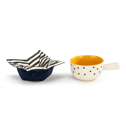 A white ceramic soup crock with black polka dots and an orange interior next to a dark blue fabric cozy with a striped interior.