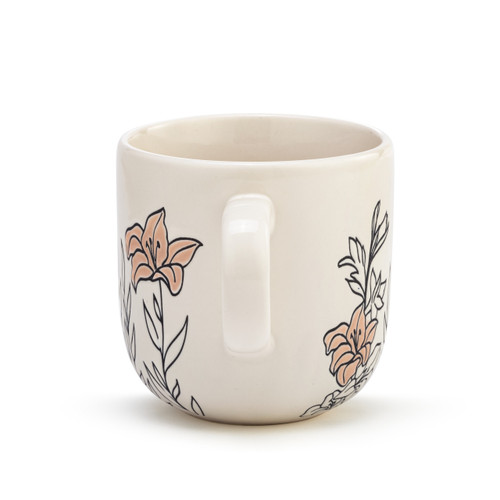 The handle of a cream coffee mug with several simple black and light pink flowers stemming from the base.