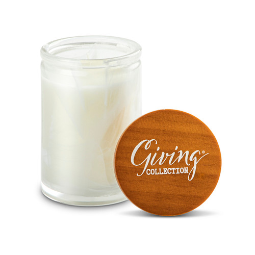 A white round glass Sunlit Citron & Sea Moss scented candle with a wood lid that says "Giving Collection" on top, displayed with the lid off and upright to the side.