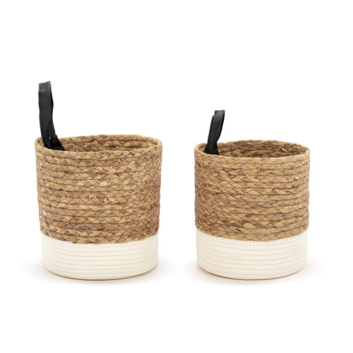 Profile view of a set of two round brown woven baskets with a black handle and cream fabric base.