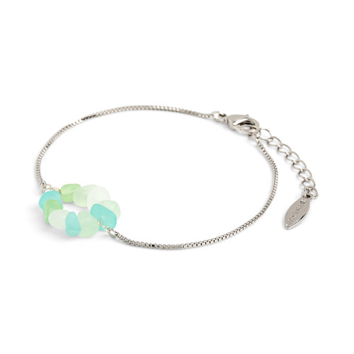 Close up angled view of a silver chain adjustable bracelet with colored glass beads in a circle in shades of green.